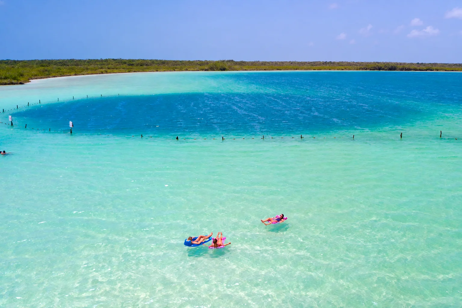 Les eaux turquoise peu profondes et le centre bleu profond de la lagune de Kaan Luum