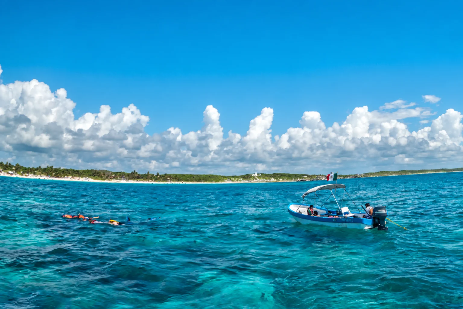 Snorkeleurs et un bateau sur la mer des Caraïbes près de Tulum